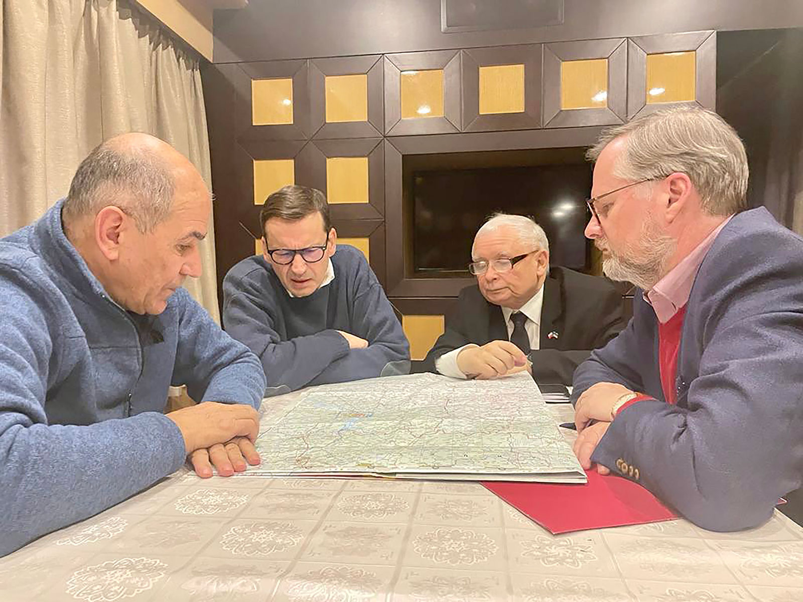 From Left: Slovenia's PM Janez Janša, Polish PM Mateusz Morawiecki, Polish deputy PM Jarosław Kaczyński, and Czech PM Petr Fiala study a map in a wood-panelled room in an undisclosed location on Tuesday.