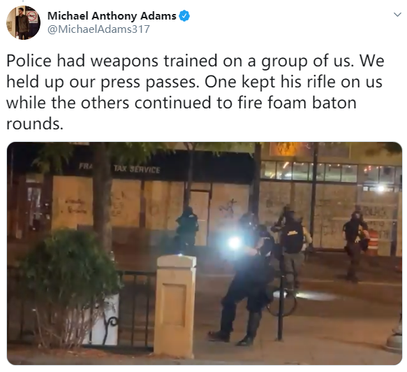 ▲迈克尔·亚当斯社交媒体发文：警察瞄准了我们，我们拿出记者证，一个人用步枪对着我们，其他人继续用泡沫弹射击。