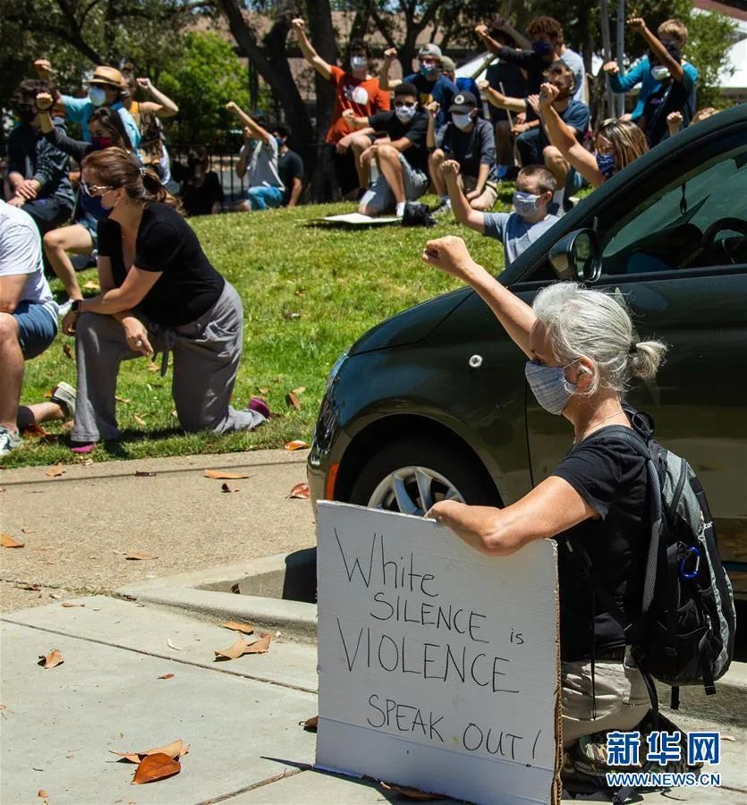 ▲6月5日，在美国加利福尼亚州旧金山湾区洛斯阿尔托斯，一名示威者手持“白人的沉默与暴力无异。请发声！”的标语参加抗议活动。新华社发（董旭东 摄）