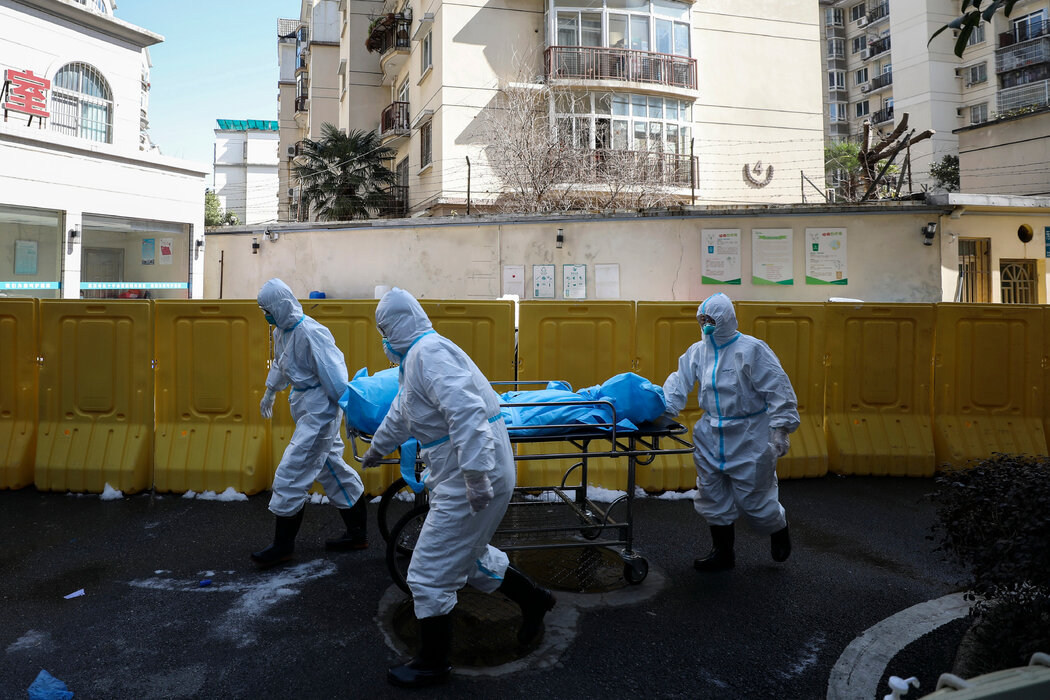2020年2月,医务人员将一名死于新冠病毒的患者移出医院。 2020年2月,医务人员将一名死于新冠病毒的患者移出医院。