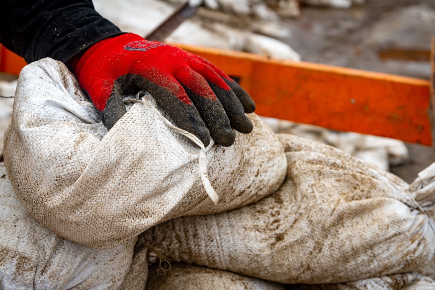 A gloved hand on a pile of sandbags