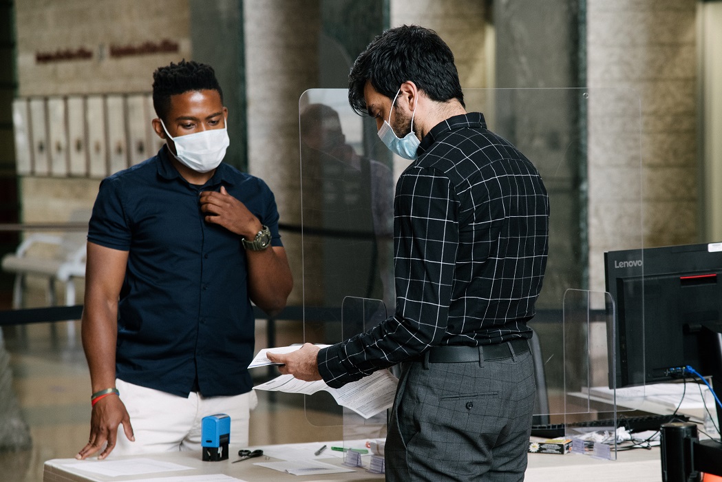 two men, doing business, wearing masks