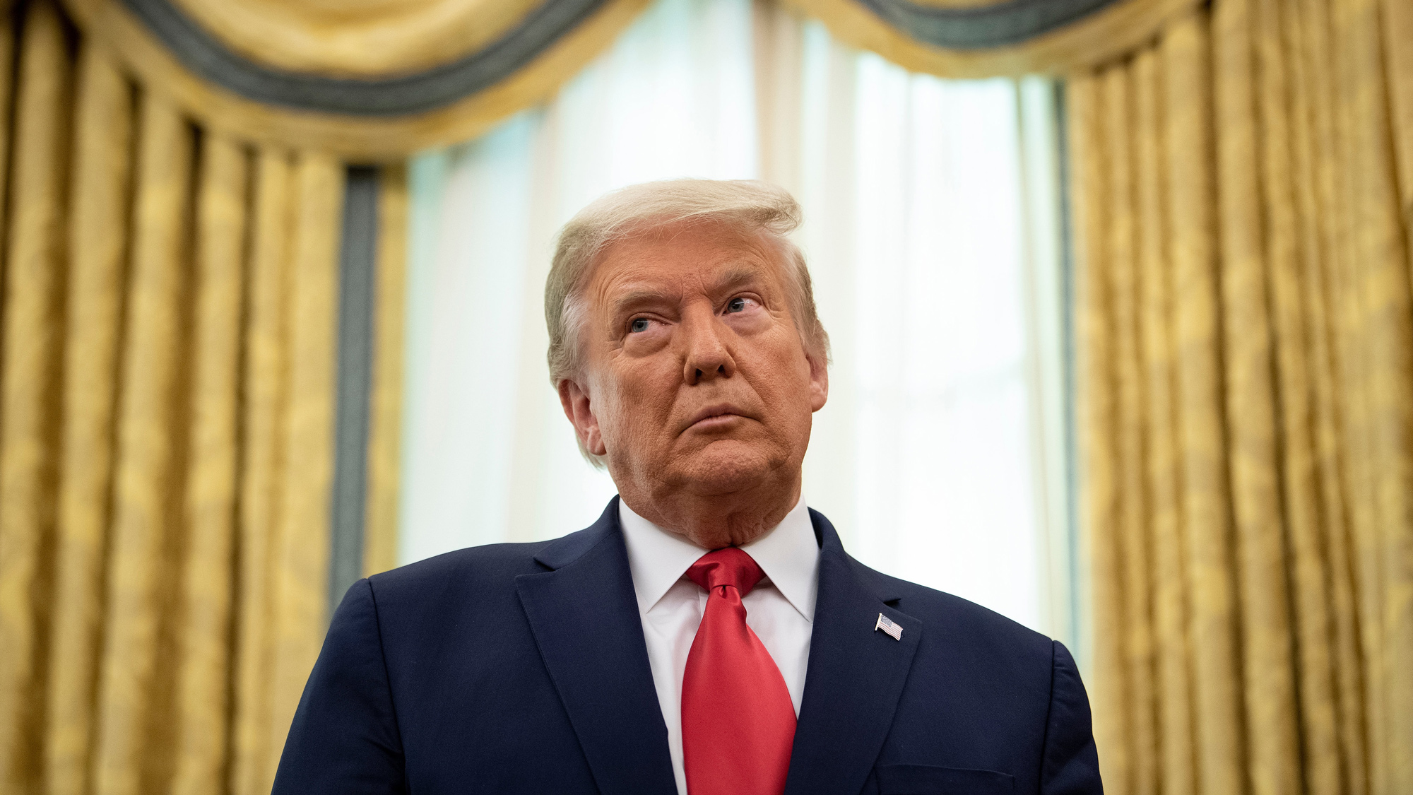 President Donald Trump listens during a Medal of Freedom ceremony in the Oval Office of the White House on December 3 in Washington, DC. 