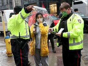 Zexi Li speaks with Ottawa Police after a protester intimidated her by moving his truck in her direction on Kent Street on Thursday, Feb. 17, 2022.