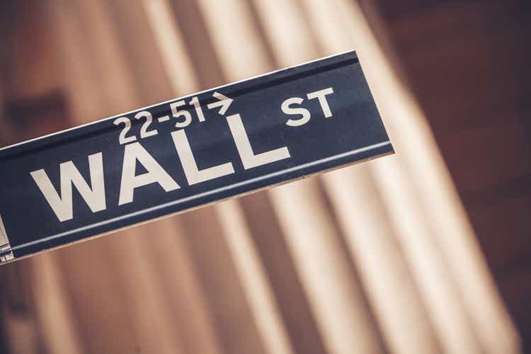 Wall street sign in New York with New York Stock Exchange background