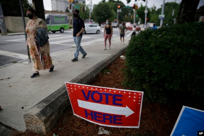 FILE - People wait in a line to vote in the Georgia's primary election at Park Tavern on Tuesday, June 9, 2020, in Atlanta. (AP Photo/Brynn Anderson)