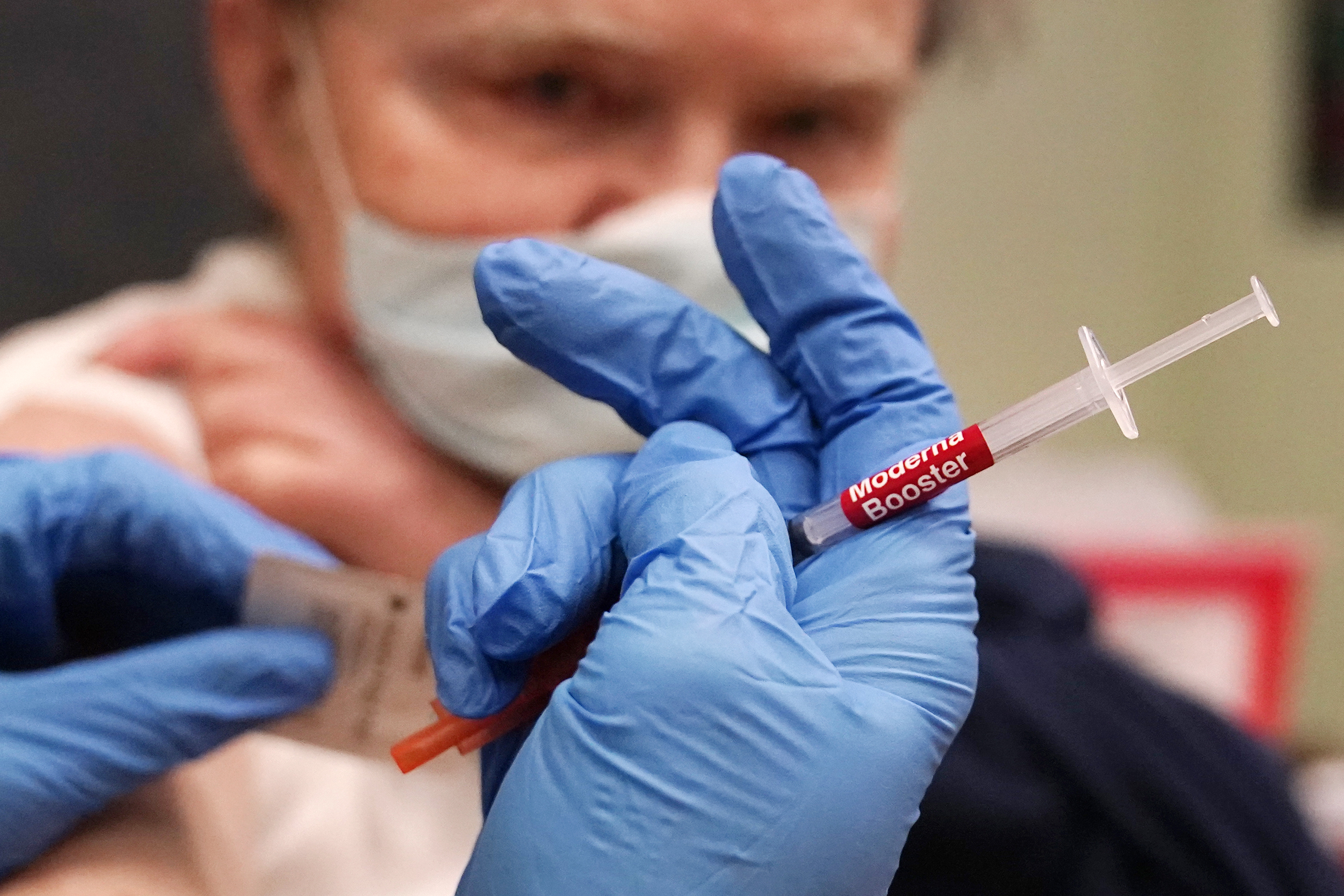 A pharmacist prepares a booster shot of the Moderna COVID-19 vaccine, last month in Lawrence, Massachusetts. 