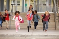 Seven young school children with backpacks are laughing and running down some steps/Sept jeunes écoliers avec des sacs à dos rient et descendent les marches en courant