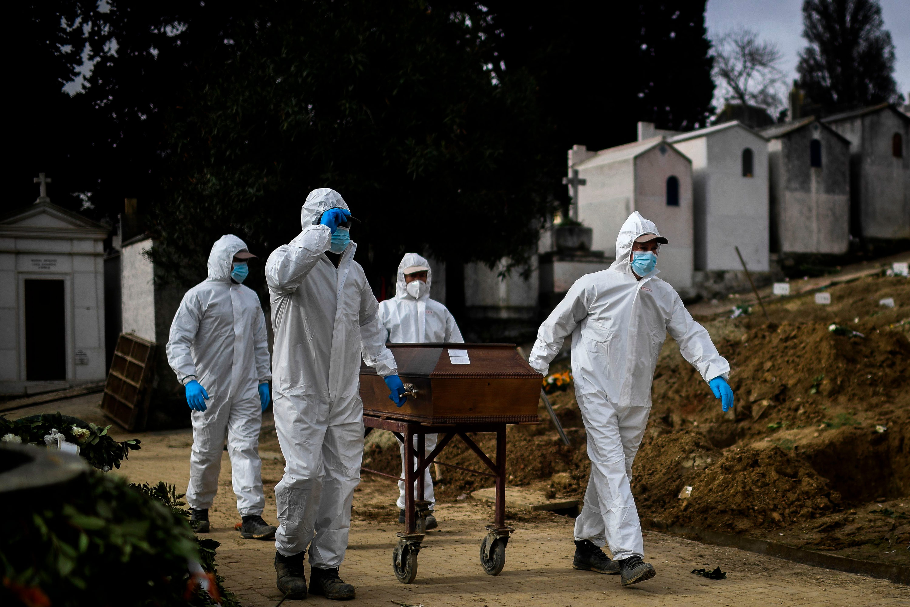 Grave diggers push the coffin of a Covid-19 victim before a burial at the Alto de Sao Joao cemetery in Lisbon, Portugal, on February 18.