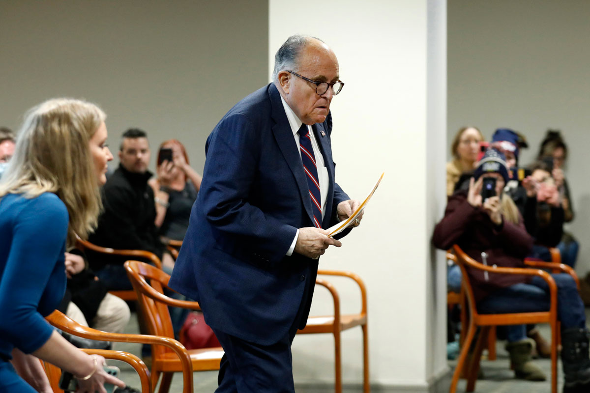 Rudy Giuliani walks to take his seat during an appearance before the Michigan House Oversight Committee in Lansing, Michigan on Dec. 2.