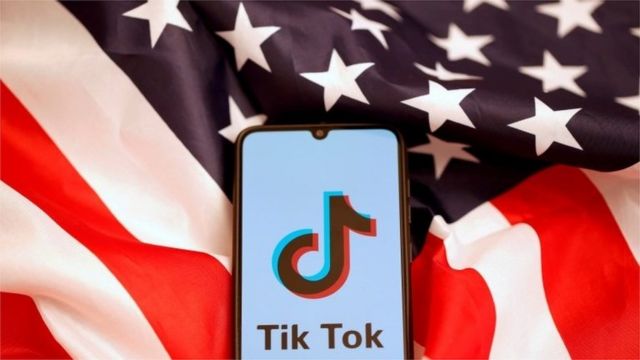 TikToks logo is displayed on the smartphone while standing on the U.S. flag in this illustration picture taken, November 8, 2019.