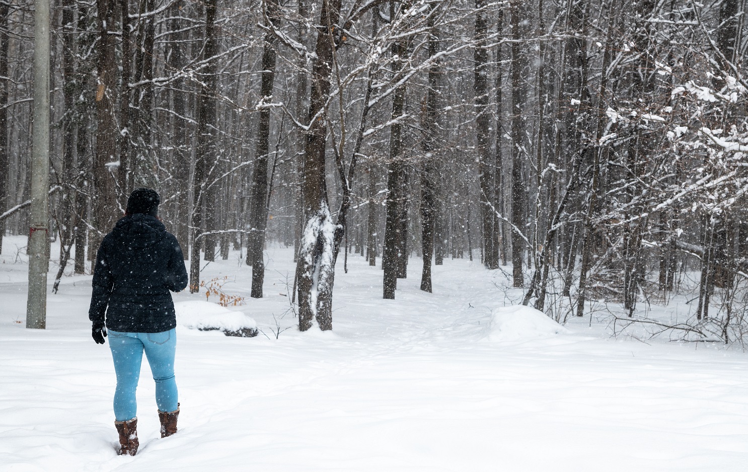 Woman walking on forest trail in the snow