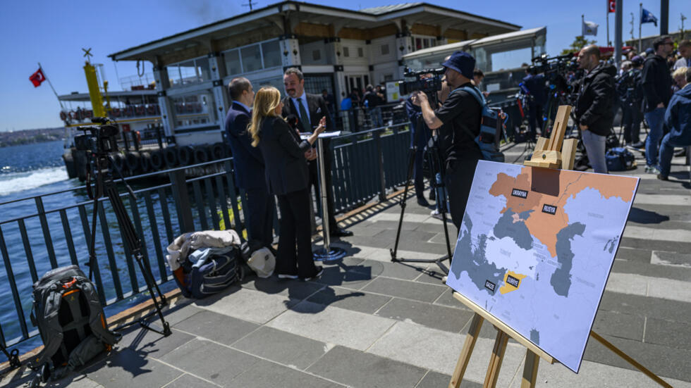 Les journalistes se tiennent devant le palais de Dolmabahce à Istanbul où doivent se tenir les discussions directes entre Russes et Ukrainiens, ce 15 mai 2025.