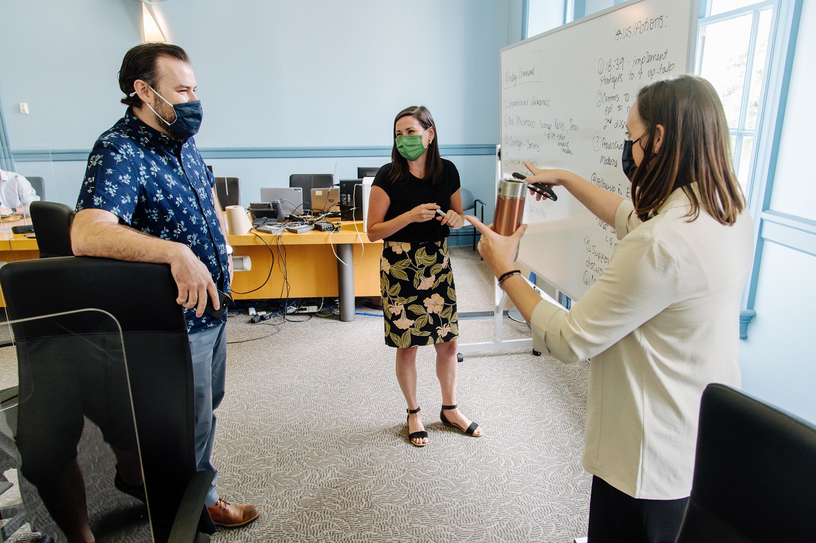 Ryan Perreault, Amanda Mullins and Melissa Lavery discuss in front of a white board