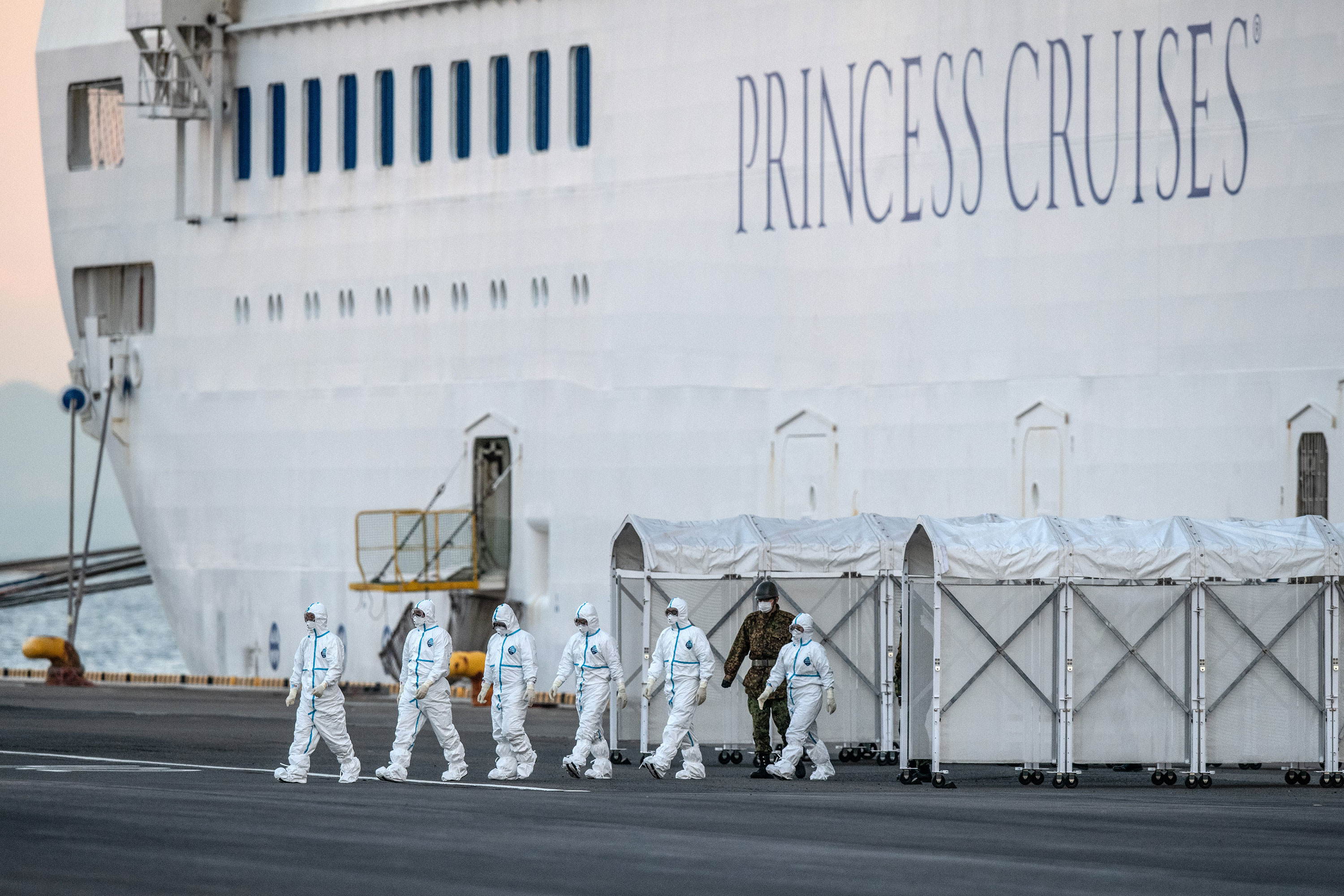 Emergency workers in protective clothing exit the Diamond Princess cruise ship at Daikoku Pier in Yokohama, Japan, on February 10.