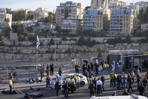 FILE - Israeli police officer and volunteers from the Zaka rescue service work at the shooting attack in Jerusalem, Thursday, Nov. 30, 2023. The shooting death of an Israeli man who raced to confront Palestinian attackers has raised questions about the use of excessive force among Israeli security forces and the public. The man's shooting mirrors previous incidents where Israeli security forces or civilians have opened fire on attackers who no longer appear to pose a threat or on suspected assailants or unarmed civilians. (AP Photo/Ohad Zwigenberg, File)