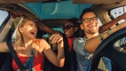 Interior of car with two women and a man smiling and laughing.