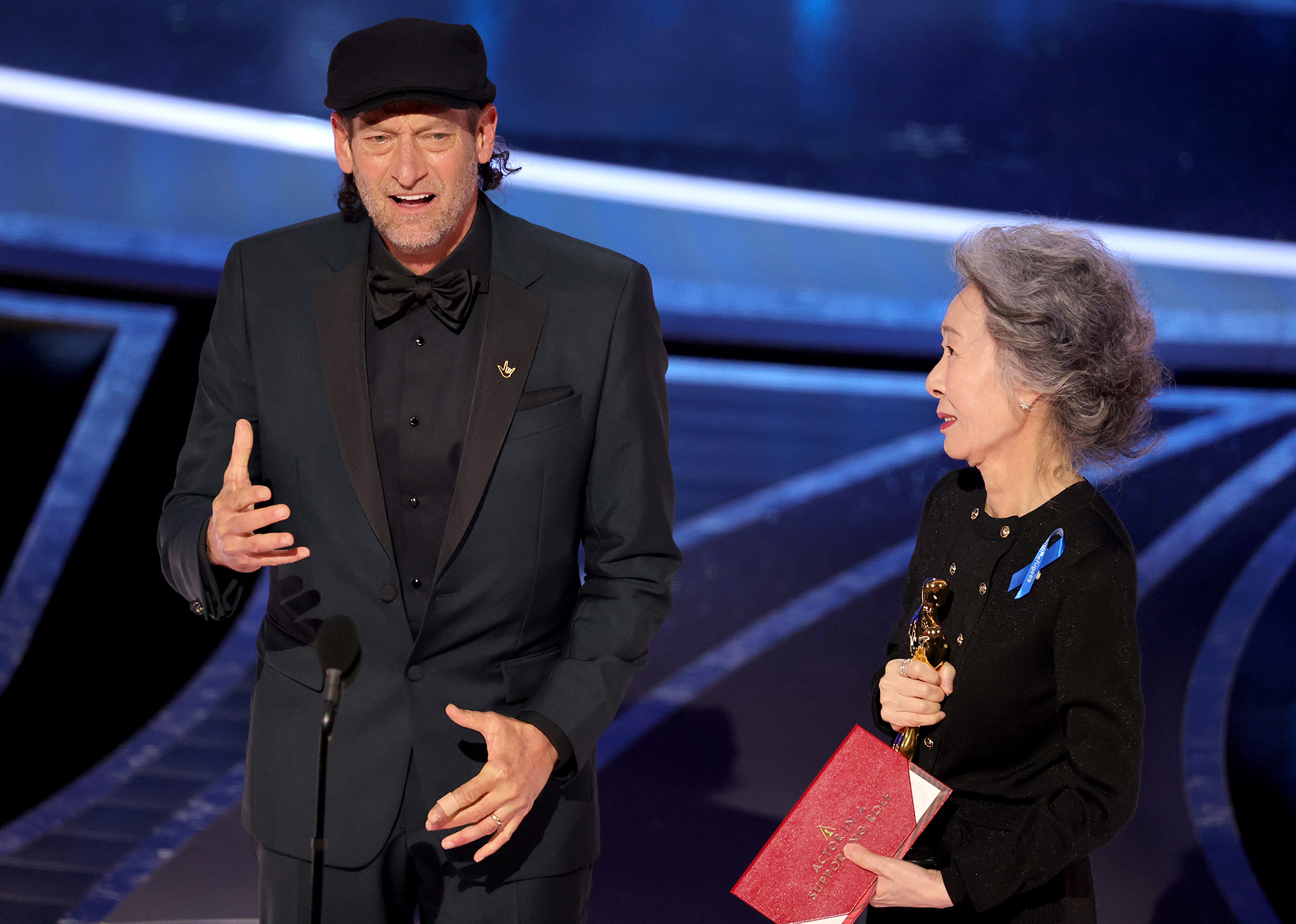 Troy Kotsur, left, accepts the actor in a supporting role award for “CODA” from Youn Yuh-jung onstage during the 94th Annual Academy Awards.