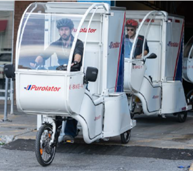 A man using a large, commercial e-cargo bike for Purolator.