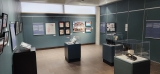 A gallery room filled with display cases, featuring blue walls with photos from the Stories from Ottawa’s Chinese-Canadian Community.