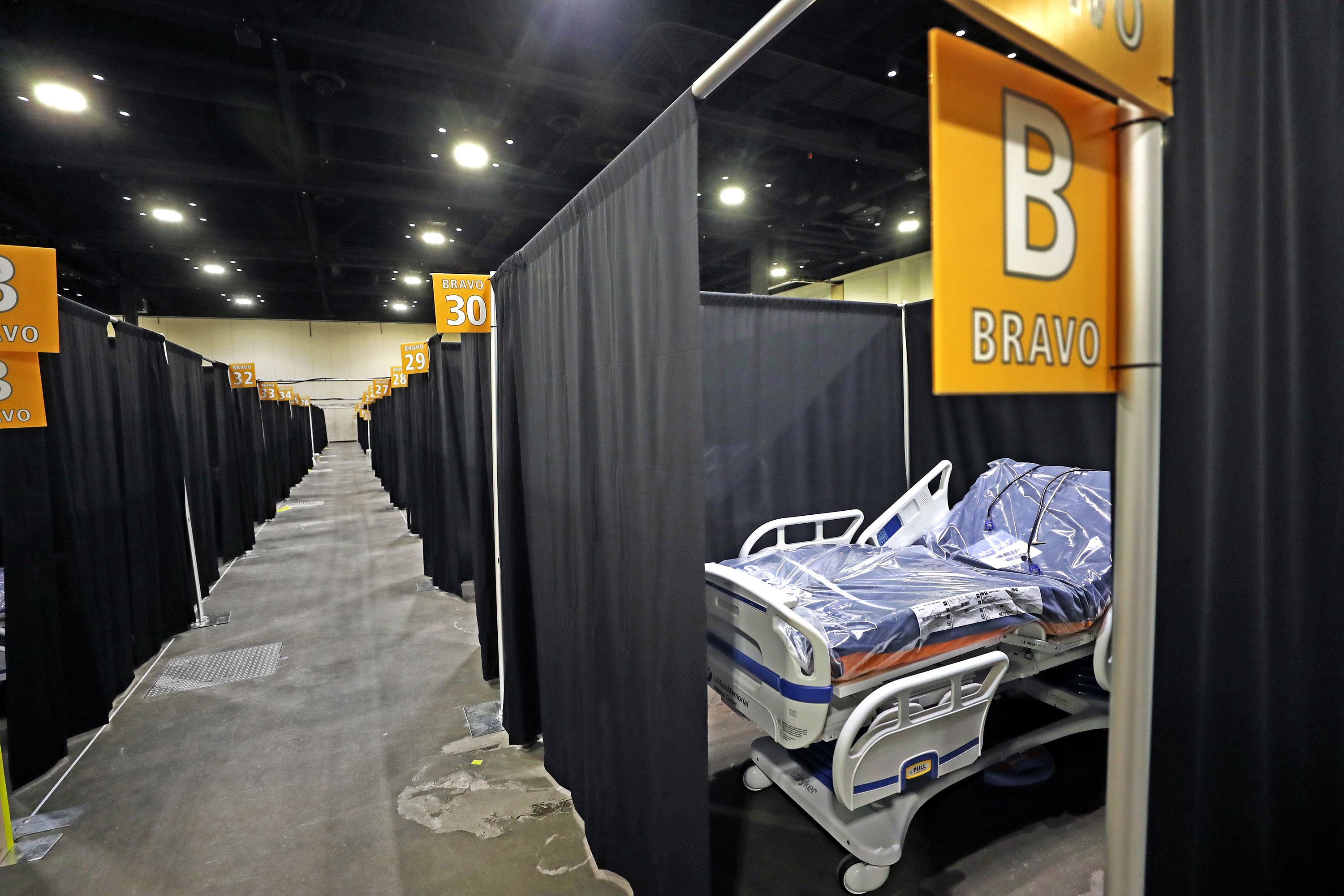 Individual hospital beds are lined up in a corridor with curtains at the new temporary hospital at the DCU in Worcester, MA on November 25. The hospital is being set up for a second time within a year.