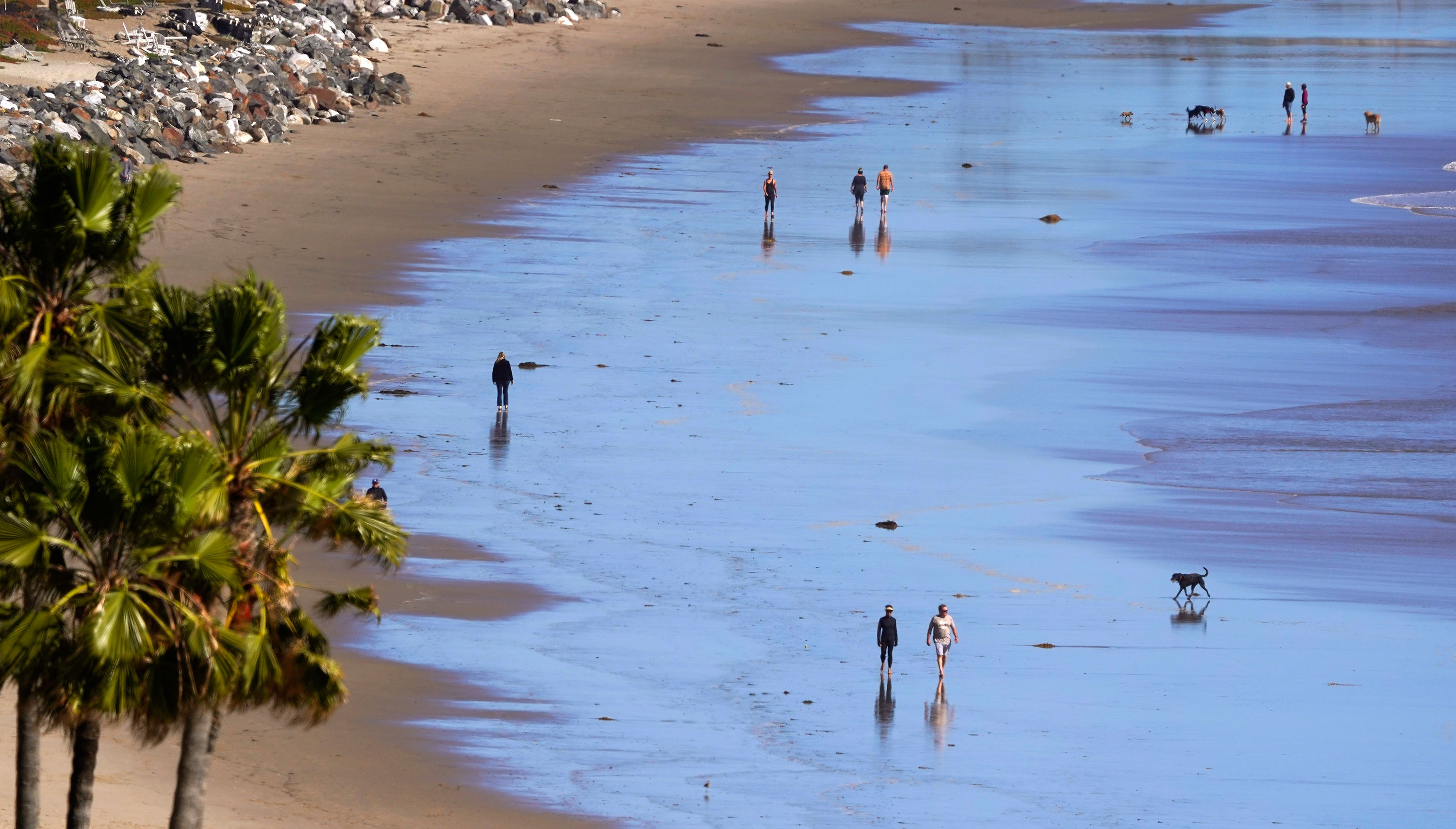 People walks along Zuma Beach, March 23, in Malibu, California.