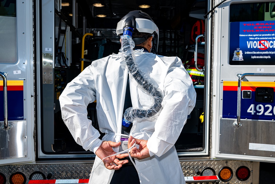 Face mask, affixed to a helmet, with an air hose leading to filtration unit on the paramedic’s belt