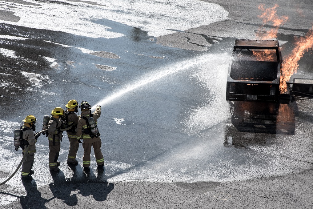 Firefighters extinguish fire with a hose