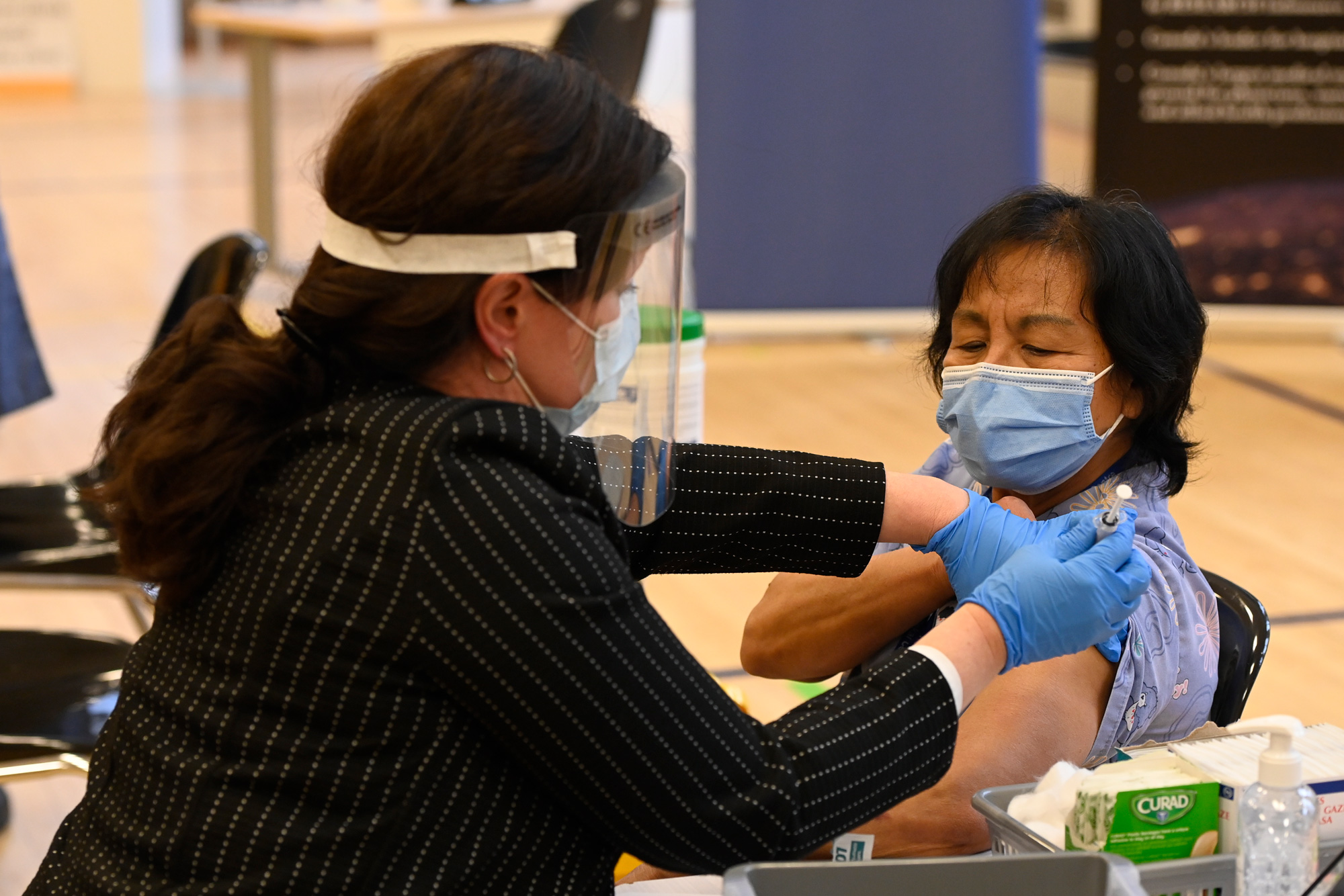 Tamara Dus, left, director of University Health Network Safety Services, administers the first Pfizer-BioNTech COVID-19 vaccine in Canada to personal support worker Anita Quidangen in Toronto on December 14.