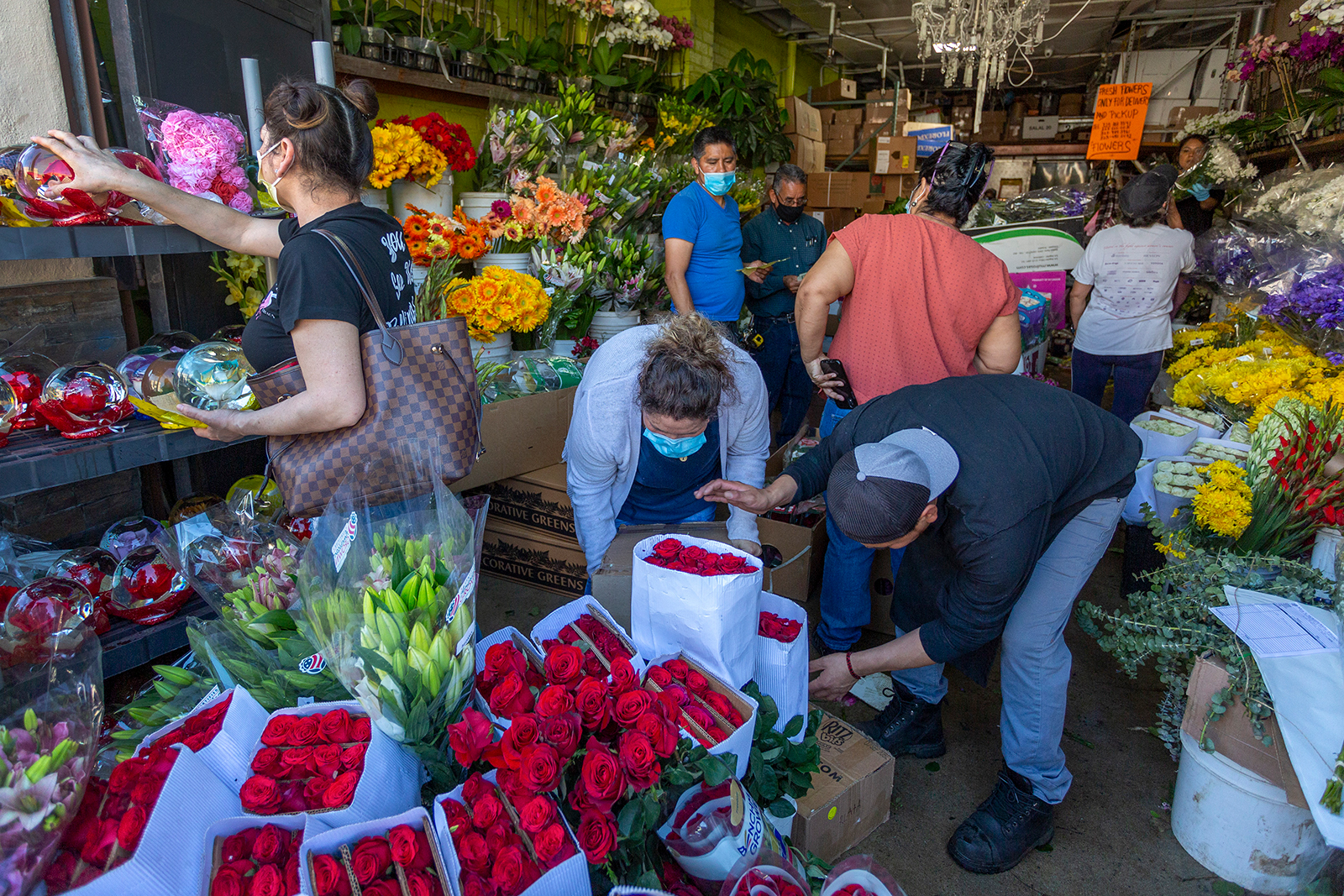 People mingle in close proximity to one another as businesses in the flower district reopen on May 8, 2020 in Los Angeles, California.