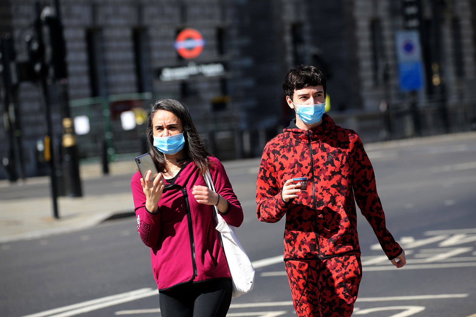 A couple wear face masks as they walk in central London on April 21.