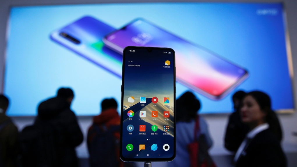 Xiaomi new model Mi 9 is displayed on an exhibition booth as invited guests try out the phones after its launch event in Beijing, Wednesday, Feb. 20, 2019. (AP Photo/Andy Wong)